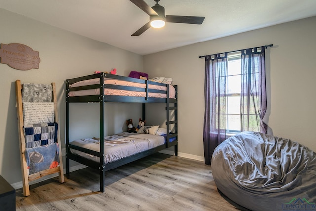 bedroom with wood finished floors, a ceiling fan, and baseboards