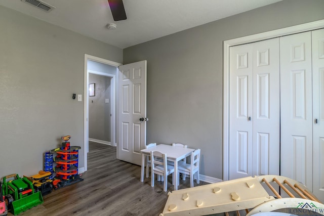 bedroom featuring baseboards, a closet, visible vents, and wood finished floors