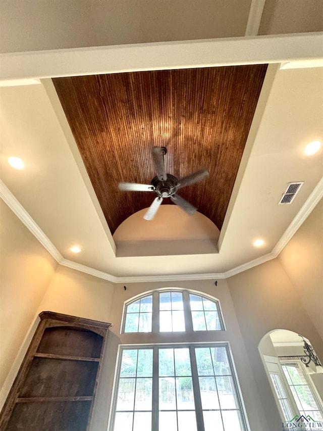 room details with visible vents, a raised ceiling, ceiling fan, arched walkways, and recessed lighting