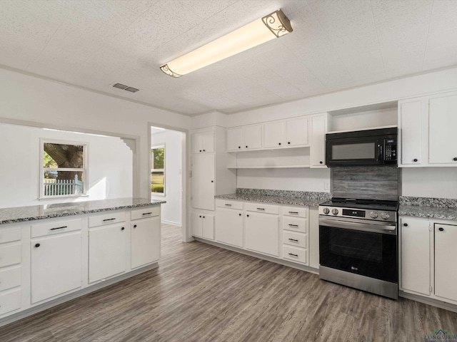 kitchen with light stone countertops, white cabinets, dark wood-type flooring, and stainless steel electric stove