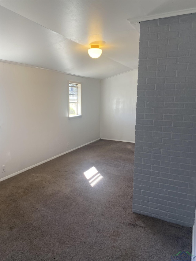 spare room with dark carpet and baseboards