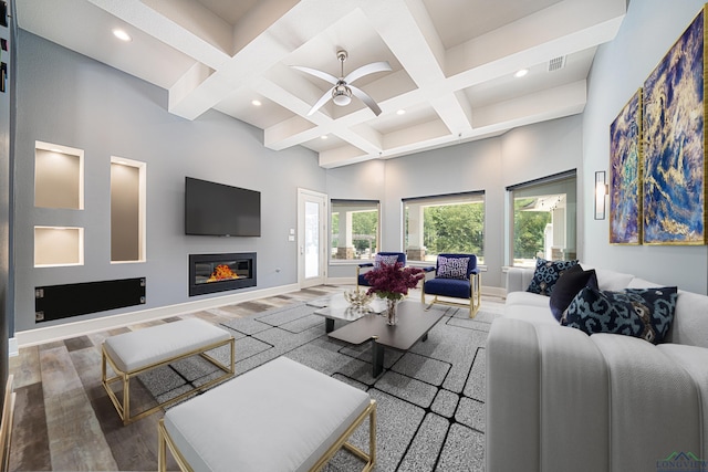 living room featuring a high ceiling, coffered ceiling, hardwood / wood-style floors, and beamed ceiling