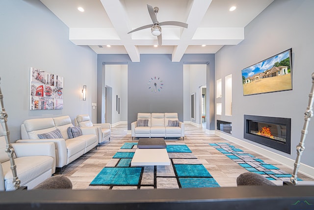 living room featuring coffered ceiling, beam ceiling, light hardwood / wood-style flooring, and ceiling fan