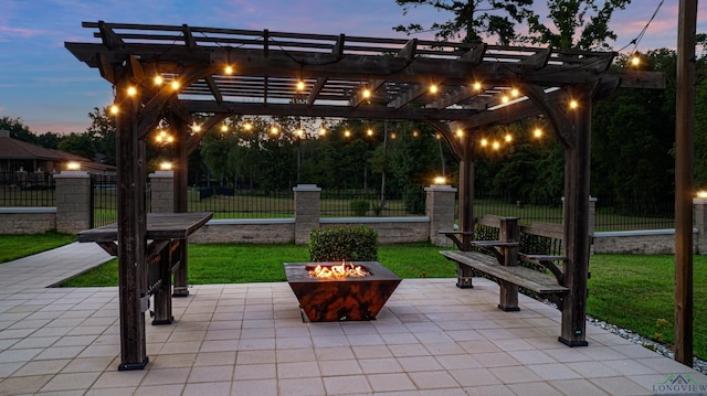 patio terrace at dusk with a yard, a pergola, and an outdoor fire pit