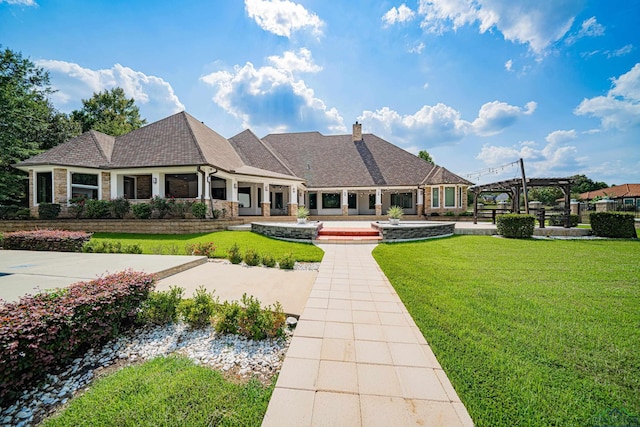 view of front of property with a pergola and a front lawn