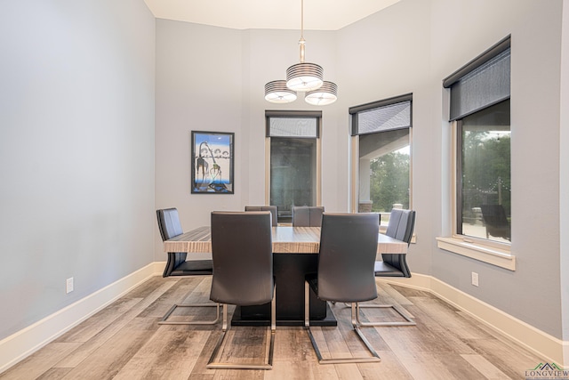 dining area featuring a notable chandelier and light wood-type flooring