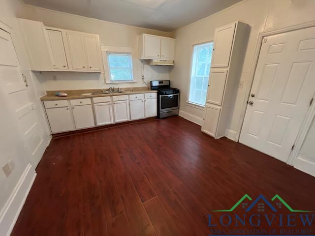 kitchen featuring stainless steel range, white cabinets, dark hardwood / wood-style floors, and sink