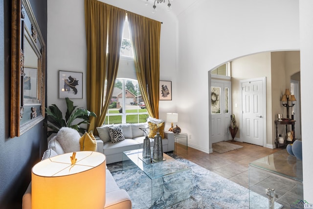 810 Crepe Myrtle Ln, Longview, TX 75604 - tiled living area with arched walkways, a high ceiling, and baseboards