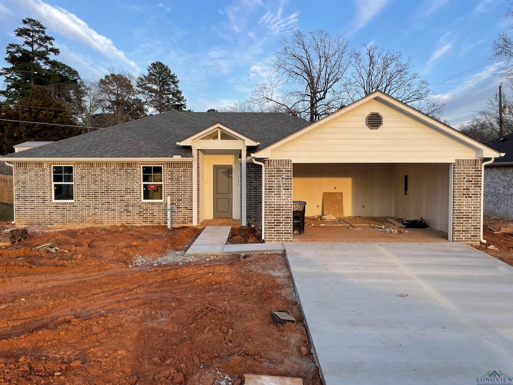 single story home with driveway, a garage, and brick siding