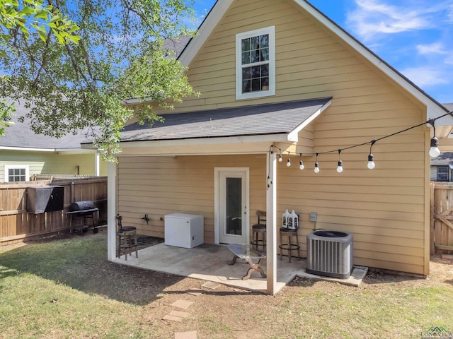 204 Hurley Ave, Gladewater, TX 75647 - back of property with central AC, a lawn, a patio area, fence, and a shingled roof