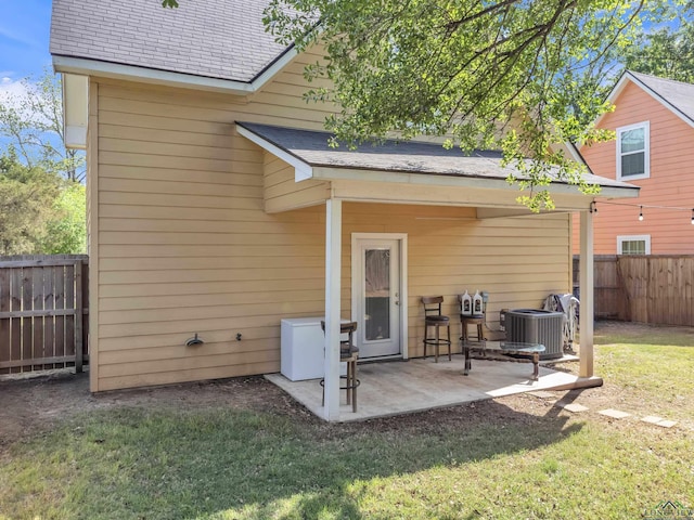 204 Hurley Ave, Gladewater, TX 75647 - back of house featuring a yard, a fenced backyard, a patio, and central air condition unit