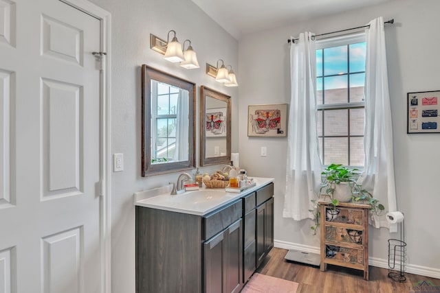 204 Hurley Ave, Gladewater, TX 75647 - bathroom with double vanity, baseboards, a sink, and wood finished floors