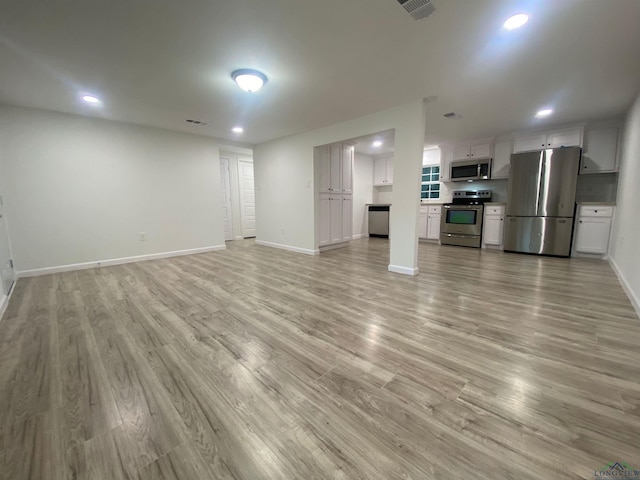 unfurnished living room with recessed lighting, light wood-style flooring, and baseboards