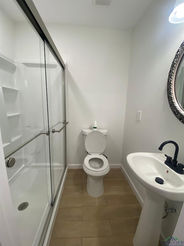 full bath featuring visible vents, baseboards, toilet, wood finish floors, and a shower stall