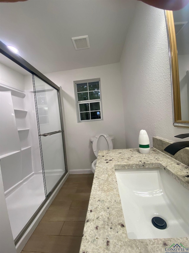 full bath featuring toilet, vanity, visible vents, baseboards, and a shower stall