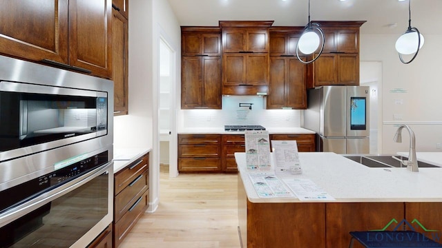 2509 Windmill Ln, Longview, TX 75601 - kitchen with appliances with stainless steel finishes, light wood finished floors, light countertops, and backsplash