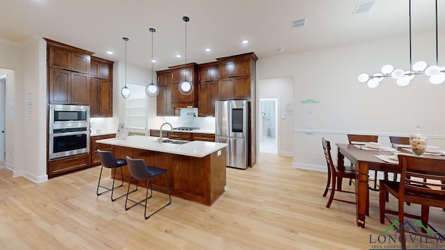 2509 Windmill Ln, Longview, TX 75601 - kitchen with appliances with stainless steel finishes, light wood finished floors, light countertops, a center island with sink, and recessed lighting