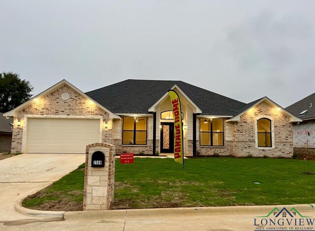 view of front of house featuring a garage and a front lawn