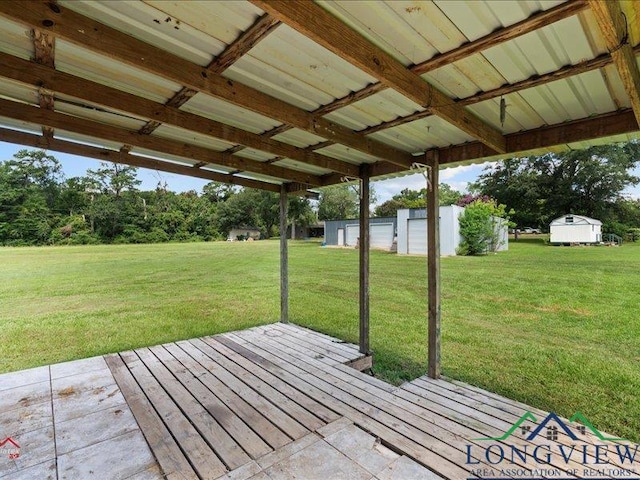 wooden deck with a lawn and an outdoor structure