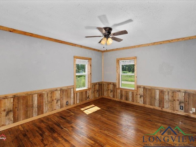 spare room featuring a textured ceiling, hardwood / wood-style flooring, plenty of natural light, and ceiling fan