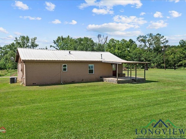 rear view of property with a lawn, cooling unit, and a patio