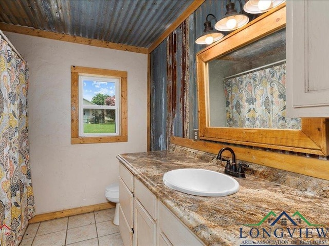 bathroom featuring tile patterned flooring, vanity, and toilet