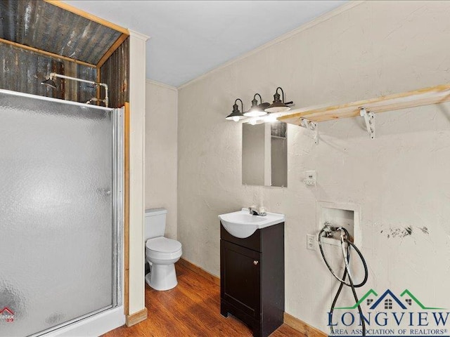 bathroom featuring vanity, hardwood / wood-style flooring, toilet, and a shower with shower door