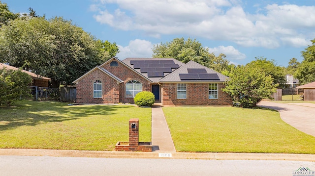 1505 Leach St, Kilgore, TX 75662 - traditional-style home with solar panels, brick siding, and a shingled roof