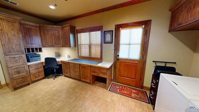 office area with light hardwood / wood-style flooring, crown molding, built in desk, and washing machine and clothes dryer