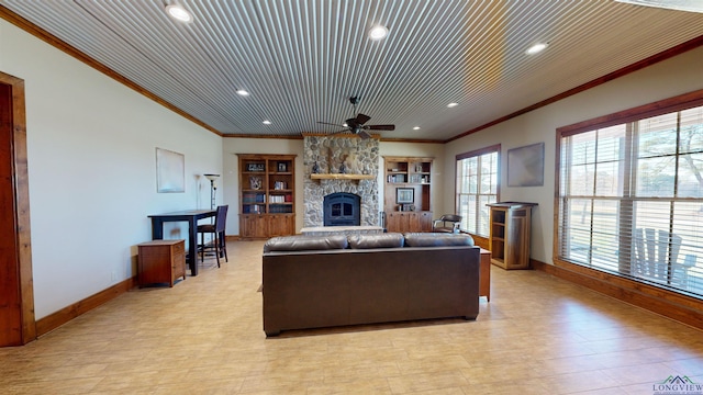 living room featuring crown molding, ceiling fan, wood ceiling, and a stone fireplace