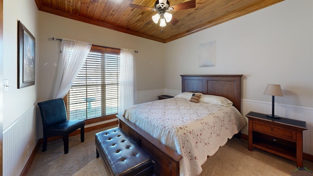 carpeted bedroom with crown molding, wood ceiling, and ceiling fan