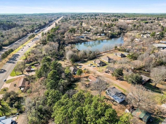 drone / aerial view featuring a water view and a forest view