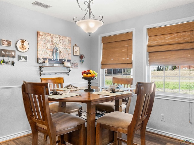 dining space with visible vents, baseboards, and wood finished floors