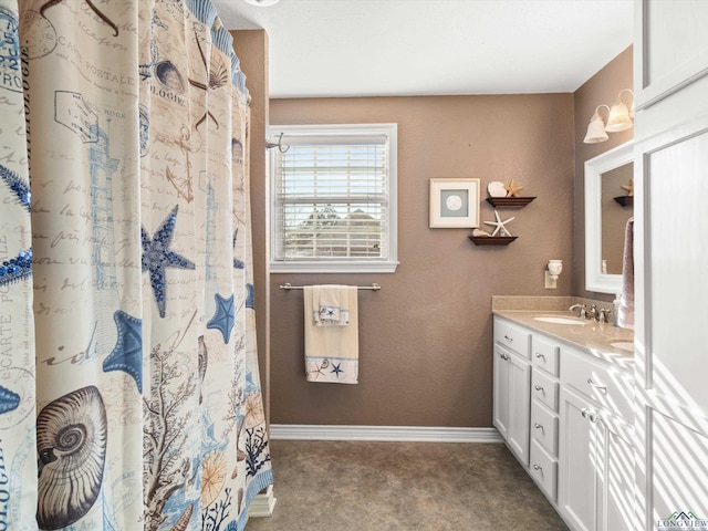 bathroom with a shower with shower curtain, vanity, and baseboards