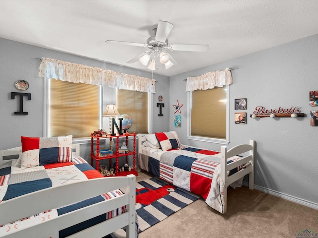 bedroom with carpet, a textured ceiling, baseboards, and a ceiling fan