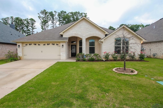 9386 Stonebank Xing, Tyler, TX 75703 - view of front of house featuring stone siding, an attached garage, concrete driveway, and a front lawn