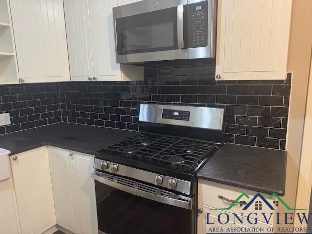 kitchen with white cabinets and appliances with stainless steel finishes