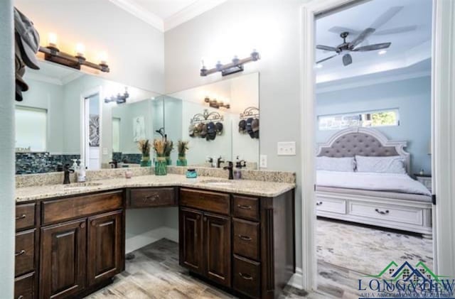 ensuite bathroom with a sink, double vanity, ensuite bath, and crown molding