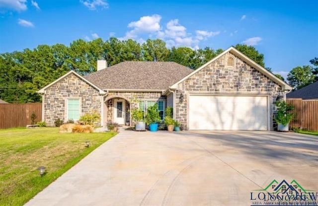 view of front facade with a chimney, an attached garage, fence, driveway, and a front lawn