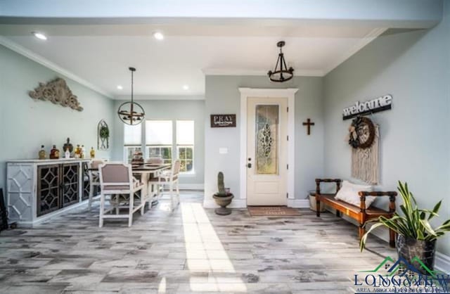 interior space featuring a chandelier, crown molding, and wood finished floors