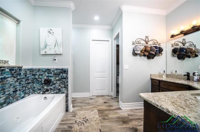 full bathroom featuring a garden tub, crown molding, vanity, wood finished floors, and baseboards