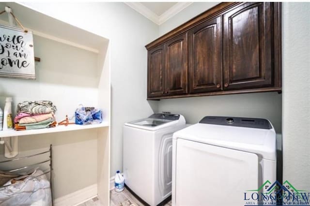 washroom featuring ornamental molding, washer and dryer, cabinet space, and light wood-style flooring