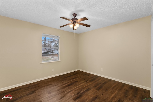 empty room with dark wood finished floors, a textured ceiling, and baseboards