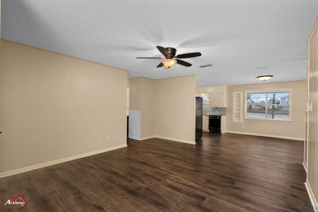 unfurnished living room featuring visible vents, a ceiling fan, dark wood-style flooring, and a textured ceiling