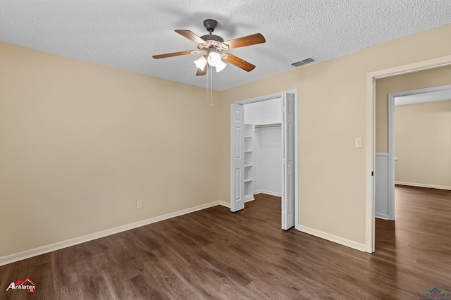 unfurnished bedroom featuring visible vents, baseboards, dark wood-type flooring, and a textured ceiling