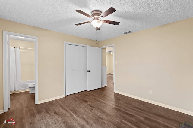 unfurnished bedroom with wood finished floors, baseboards, visible vents, a closet, and a textured ceiling