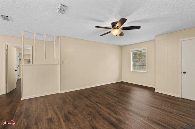 empty room featuring ceiling fan, visible vents, a textured ceiling, and dark wood finished floors