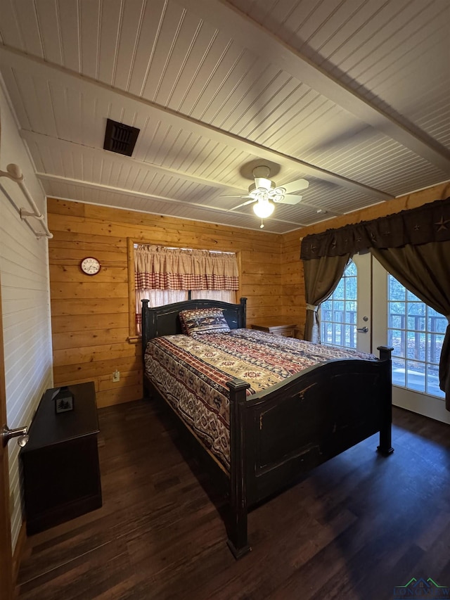 bedroom featuring access to exterior, wooden walls, ceiling fan, and dark hardwood / wood-style floors