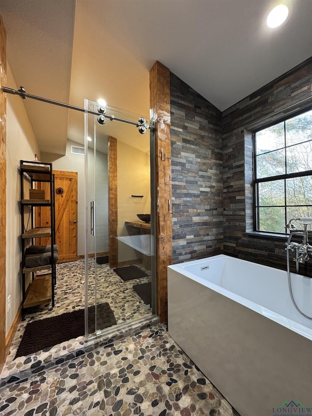 bathroom featuring lofted ceiling and plus walk in shower