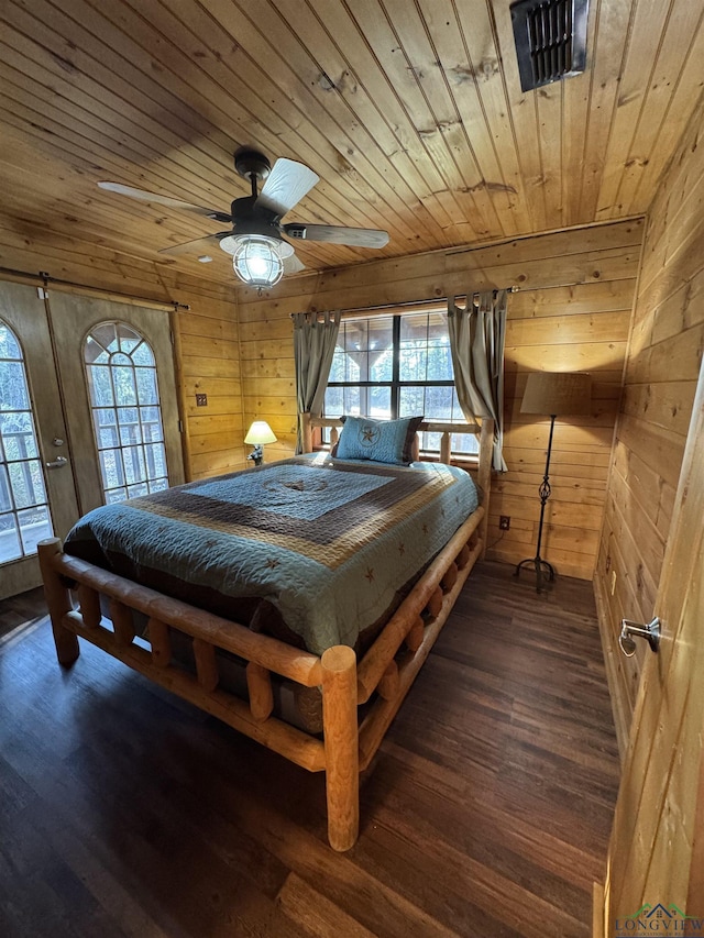 bedroom with wood walls, dark wood-type flooring, ceiling fan, and wooden ceiling